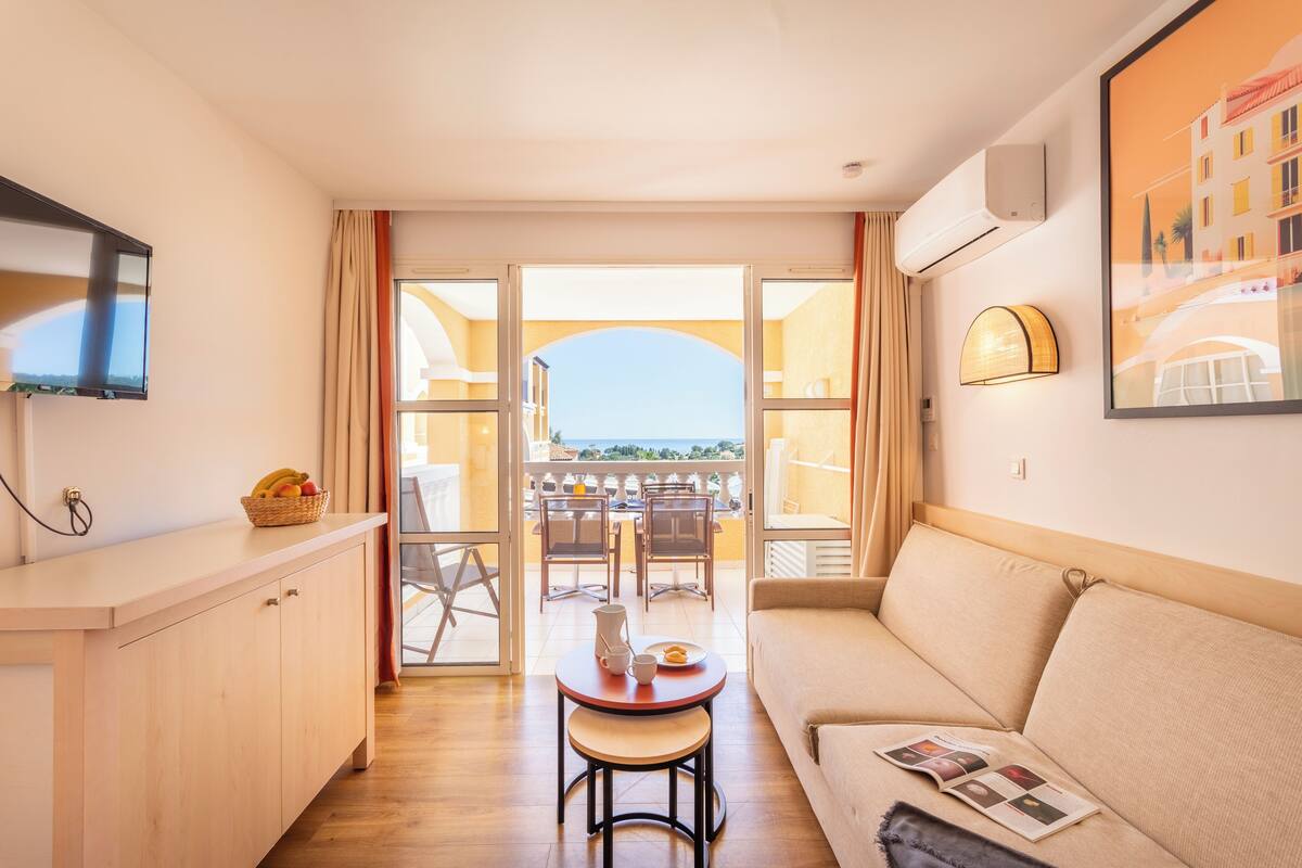 Une chambre d’hôtel moderne dotée d’un balcon, d’un coin repas et d’un canapé.