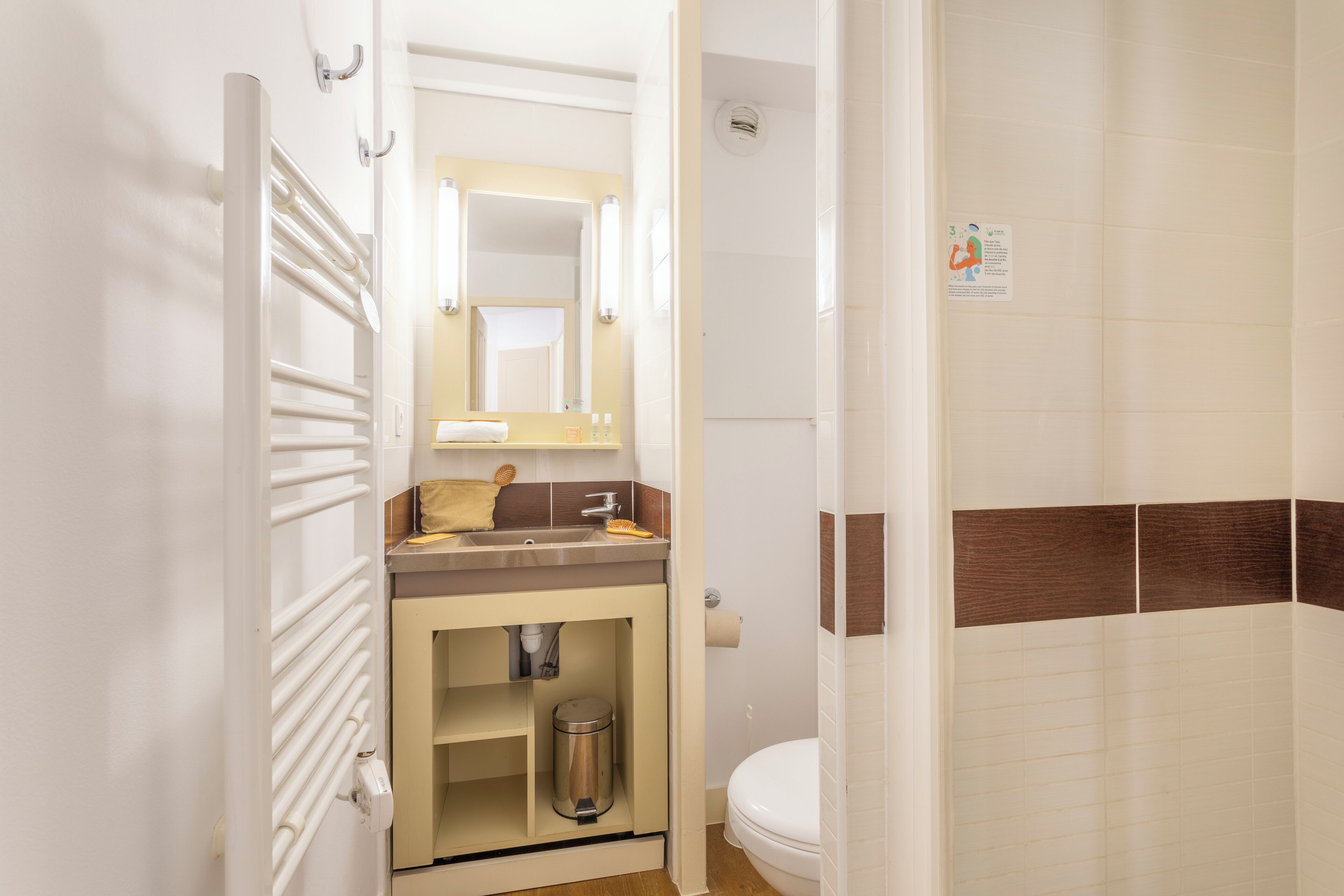 Un baño con lavamanos, espejo, inodoro y ducha.
