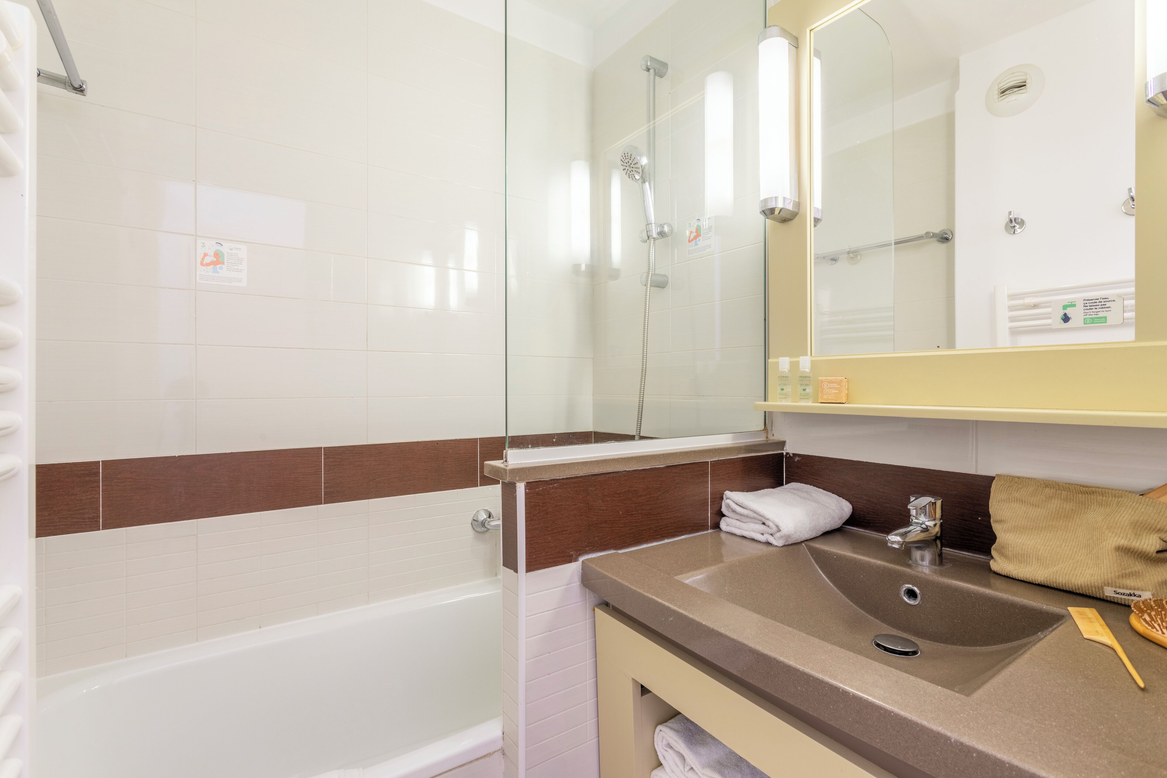 Une salle de bain avec une baignoire, un lavabo et un miroir.