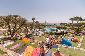 Una piscina al aire libre de temporada, sombrillas, tumbonas