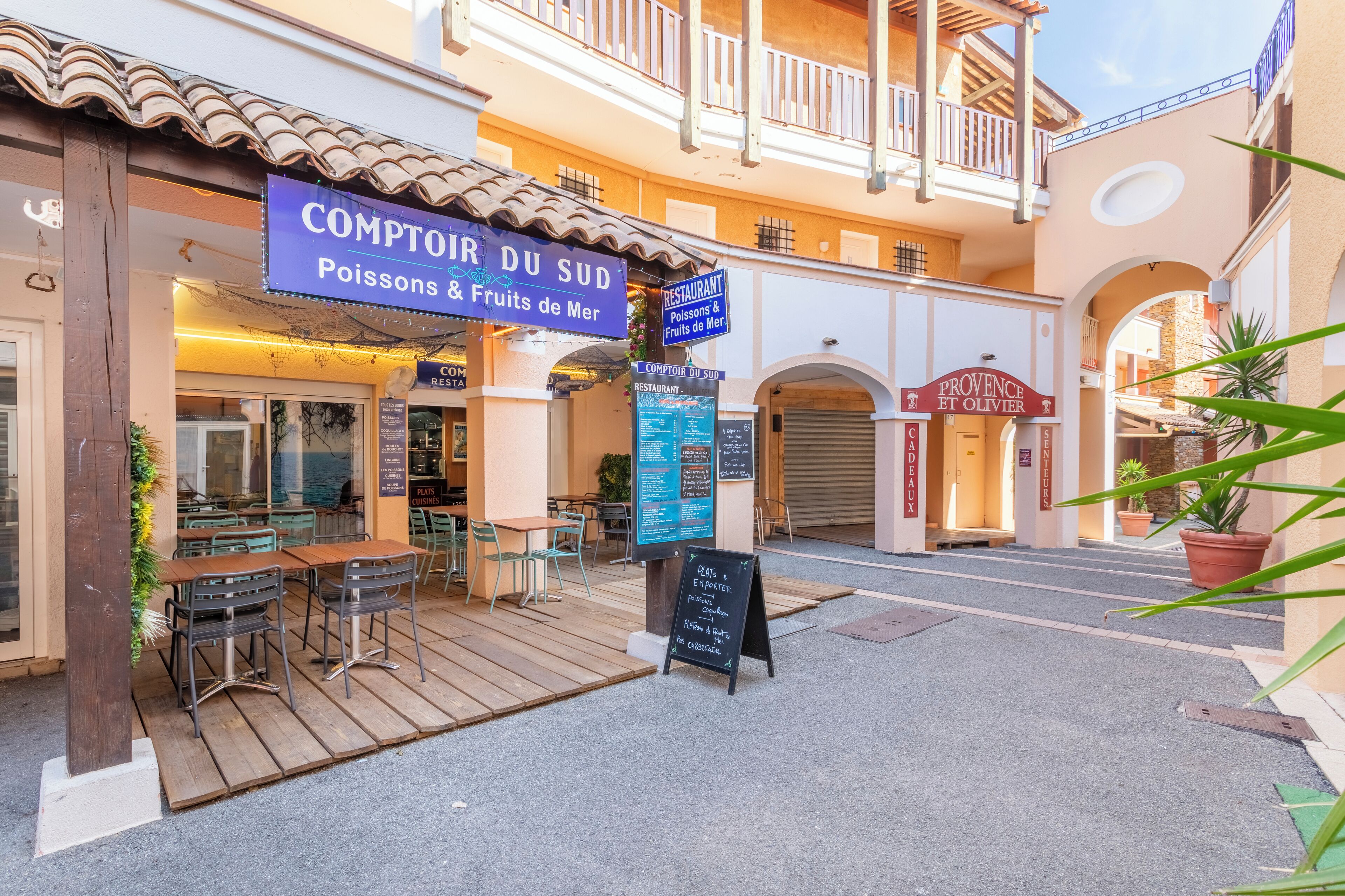 A restaurant named 'Comptoir du Sud' with outdoor seating and a signboard.