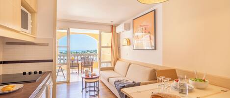 A modern kitchen with a dining area, a balcony with a view, and a cozy seating area.