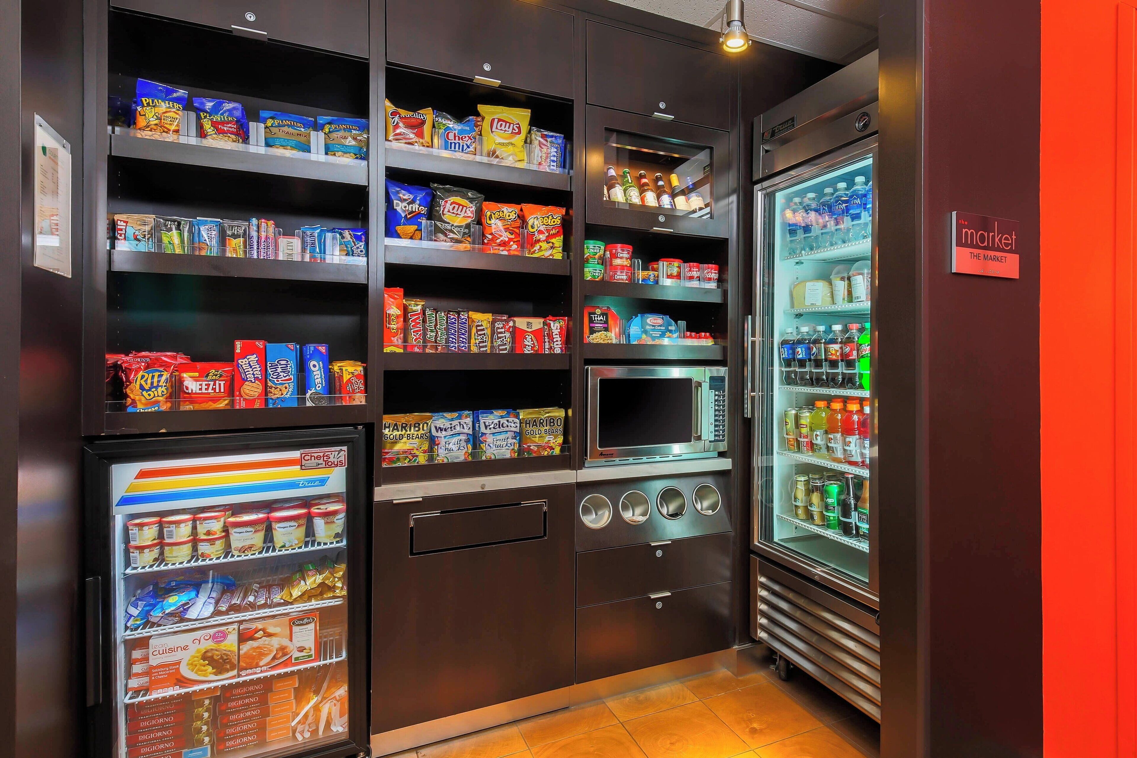 A vending machine area with snacks, beverages, and a microwave.