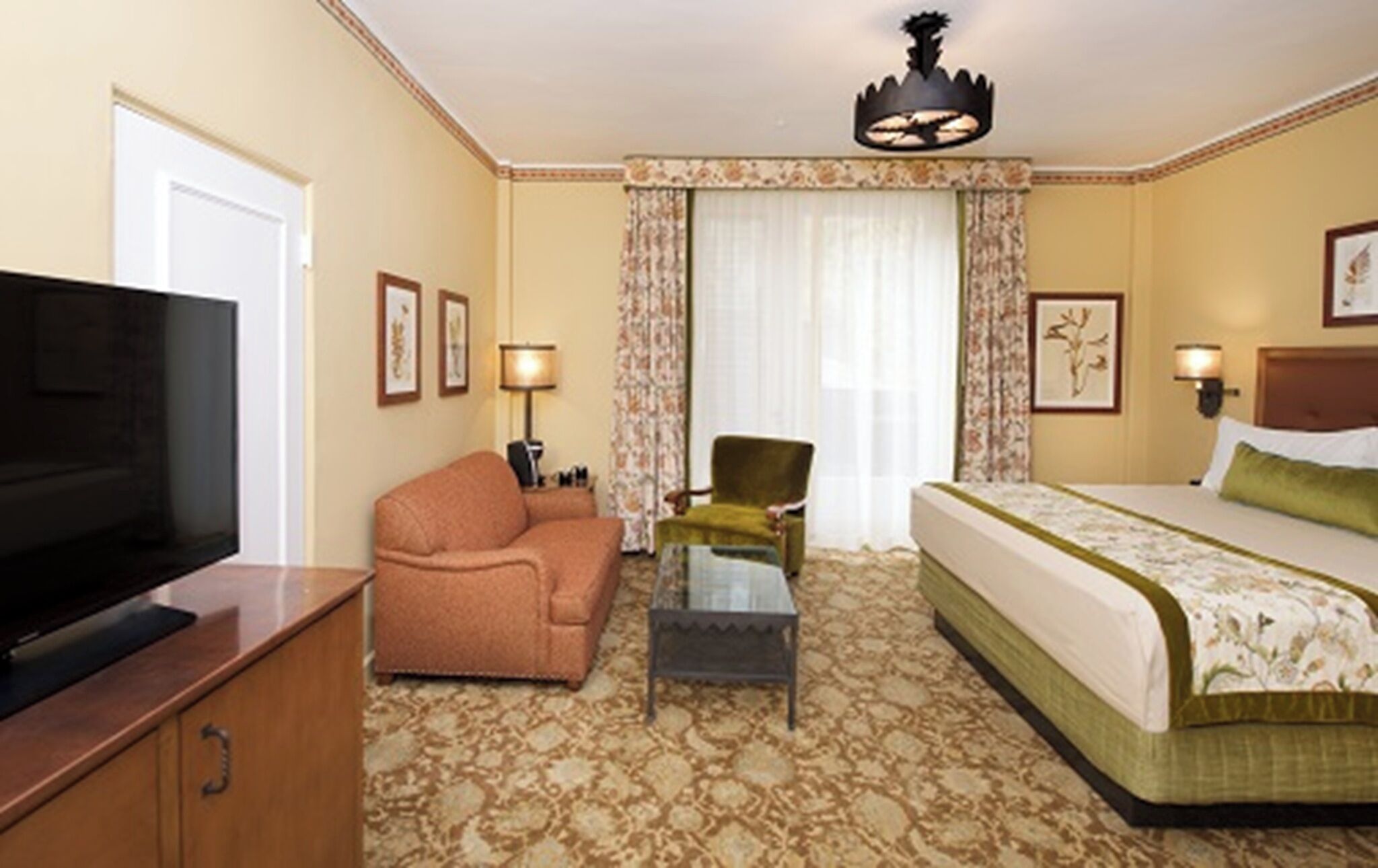 Une chambre d’hôtel comprenant un lit, un canapé, une télévision, un bureau et une chaise.