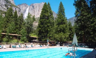 Una piscina al aire libre, sombrillas, tumbonas