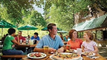 An outdoor dining area with tables, umbrellas, and a sign reading "PIZZA PATIO".