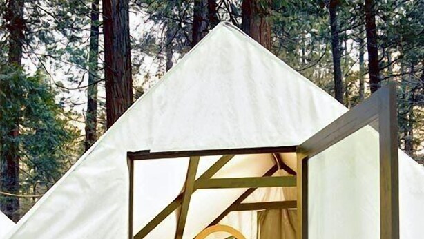 A tent with a bed, a chair, and a desk.