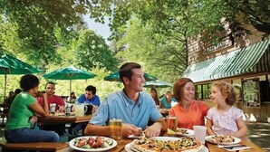 An outdoor dining area with tables, umbrellas, and a sign reading "PIZZA PATIO".