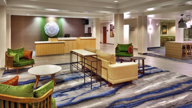 A spacious lobby with a reception desk, seating area, and a dining area.