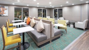 A modern lounge area with seating arrangements, including sofas and chairs, and a small table.