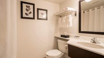 A bathroom with a toilet, sink, and towel rack. There are two framed pictures on the wall.