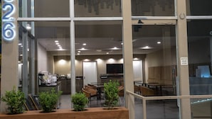A modern interior with a reception desk, seating area, and a visible staircase. - Hotel Xilo Glendale (Glendale)