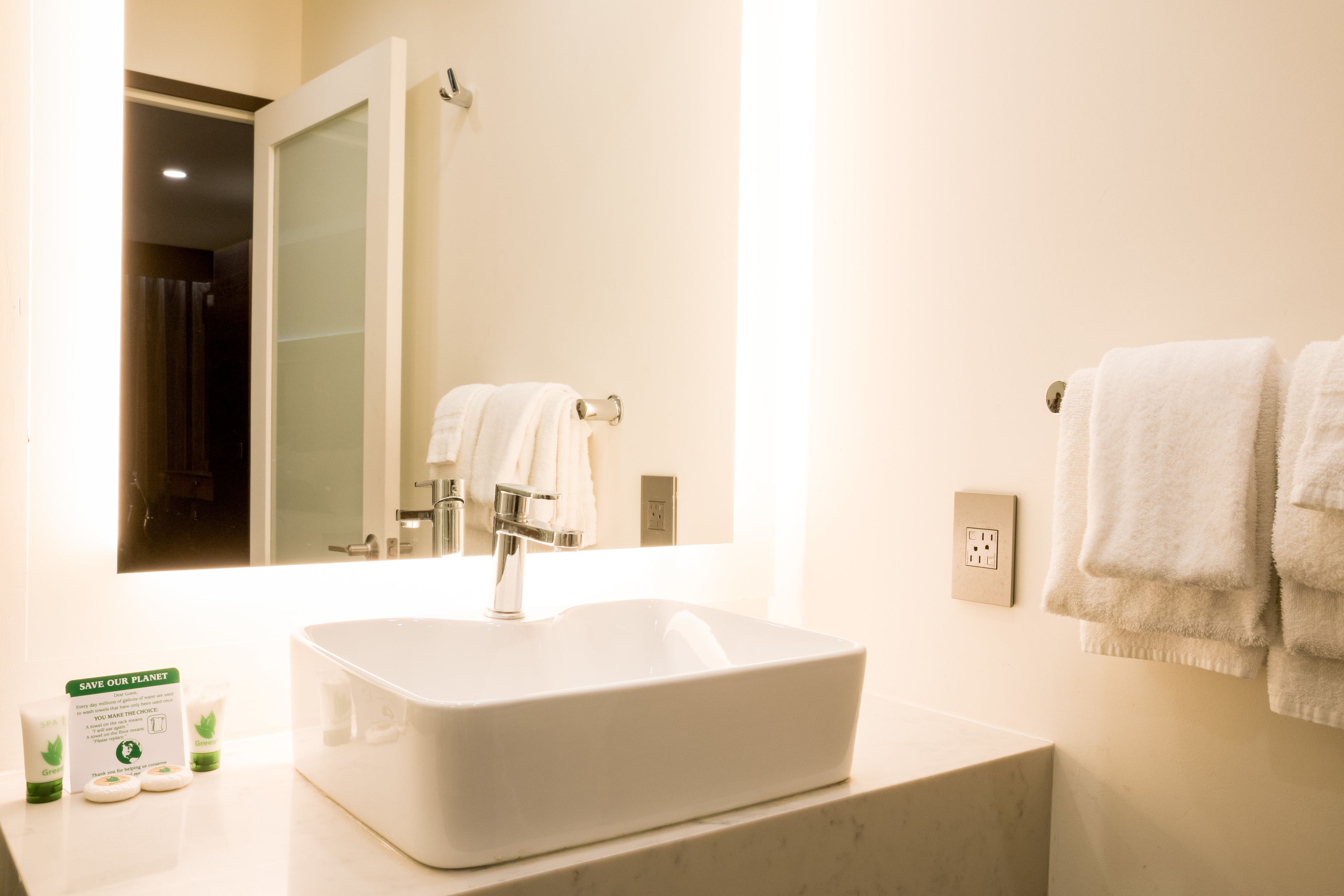 A bathroom with a white sink, a mirror, and a towel rack.