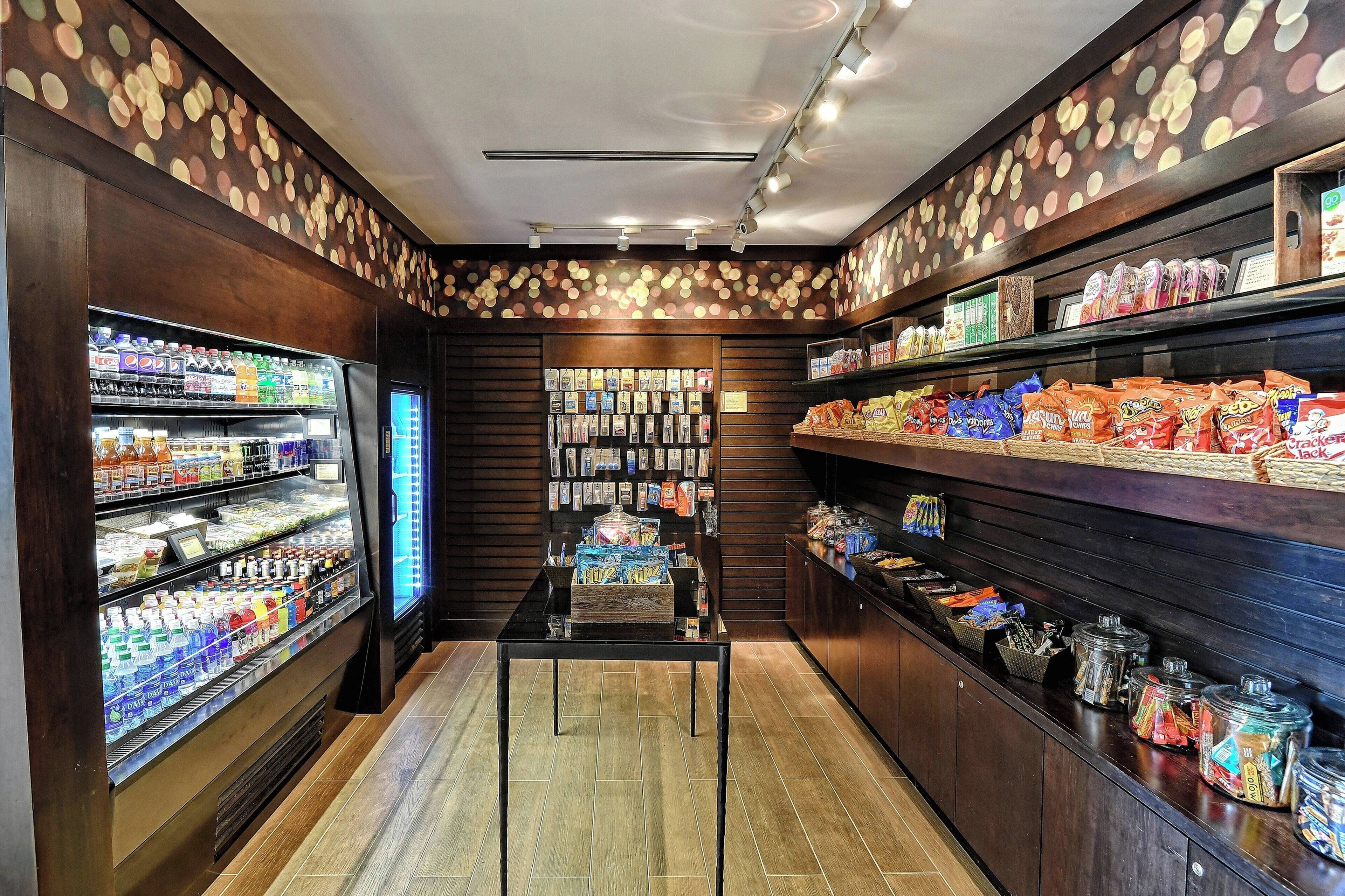 Un bar servant des collations, avec des étagères remplies de divers produits et un présentoir réfrigéré.