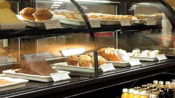 A bakery display case with pastries and a beverage section with various drinks.