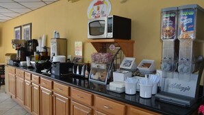 Un bancone con una macchina del caffè, un forno a microonde e un frigorifero fornito di bevande.