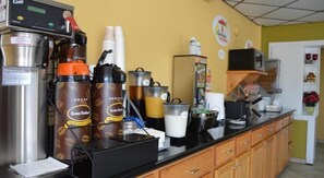 A coffee station with multiple coffee dispensers, a refrigerator, and a microwave. - Super 8 by Wyndham Clinton OK (Clinton)