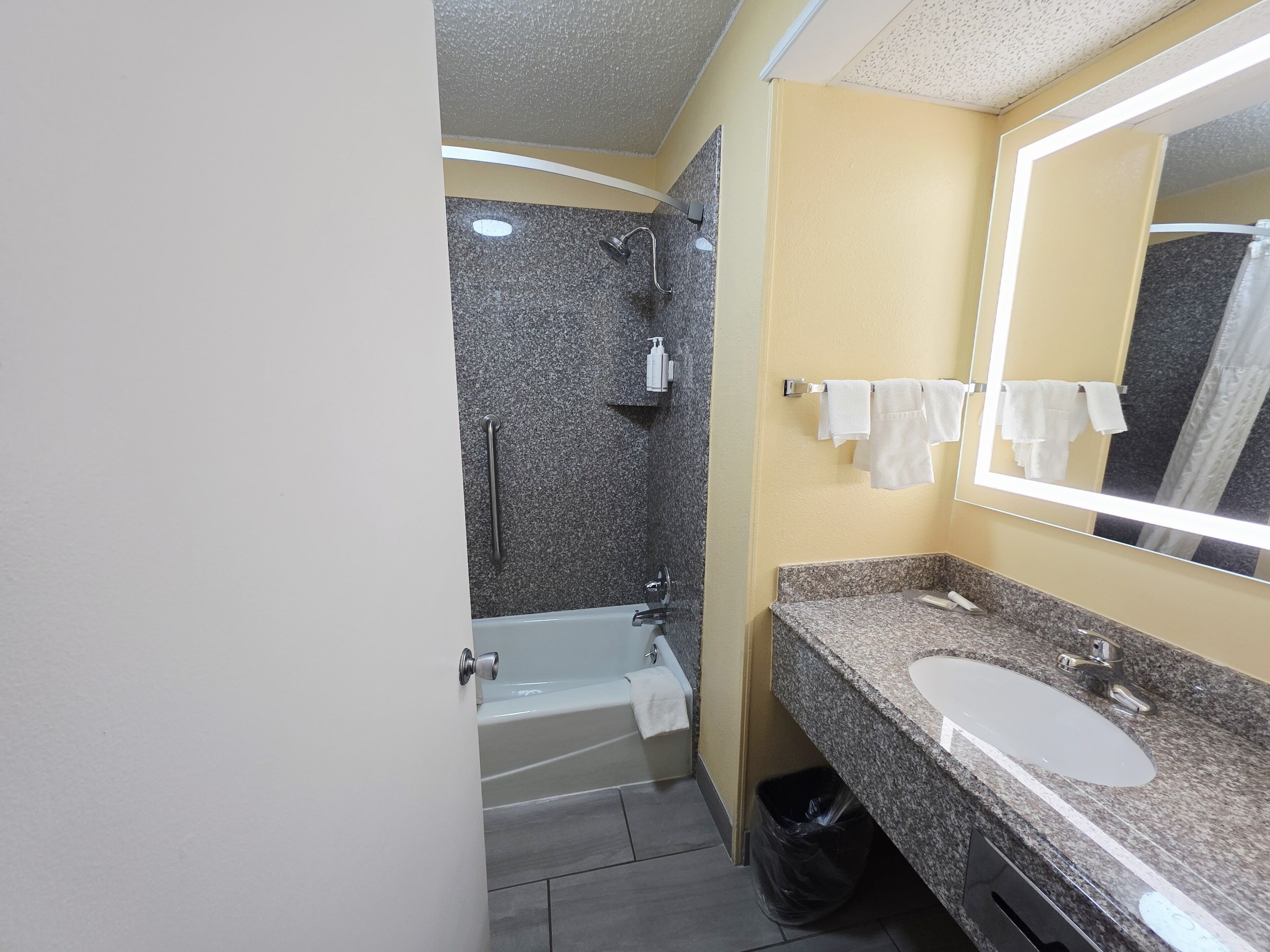 A bathroom with a bathtub, a sink, a mirror, and a shower.