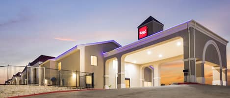 A hotel with a modern architectural design, featuring a prominent entrance with a covered area and a visible sign above the entrance.
