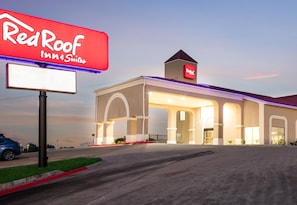 A Red Roof Inn Suites building with a prominent sign, a covered entrance, and a parking lot. - Red Roof Inn & Suites Austin East - Manor (Manor)