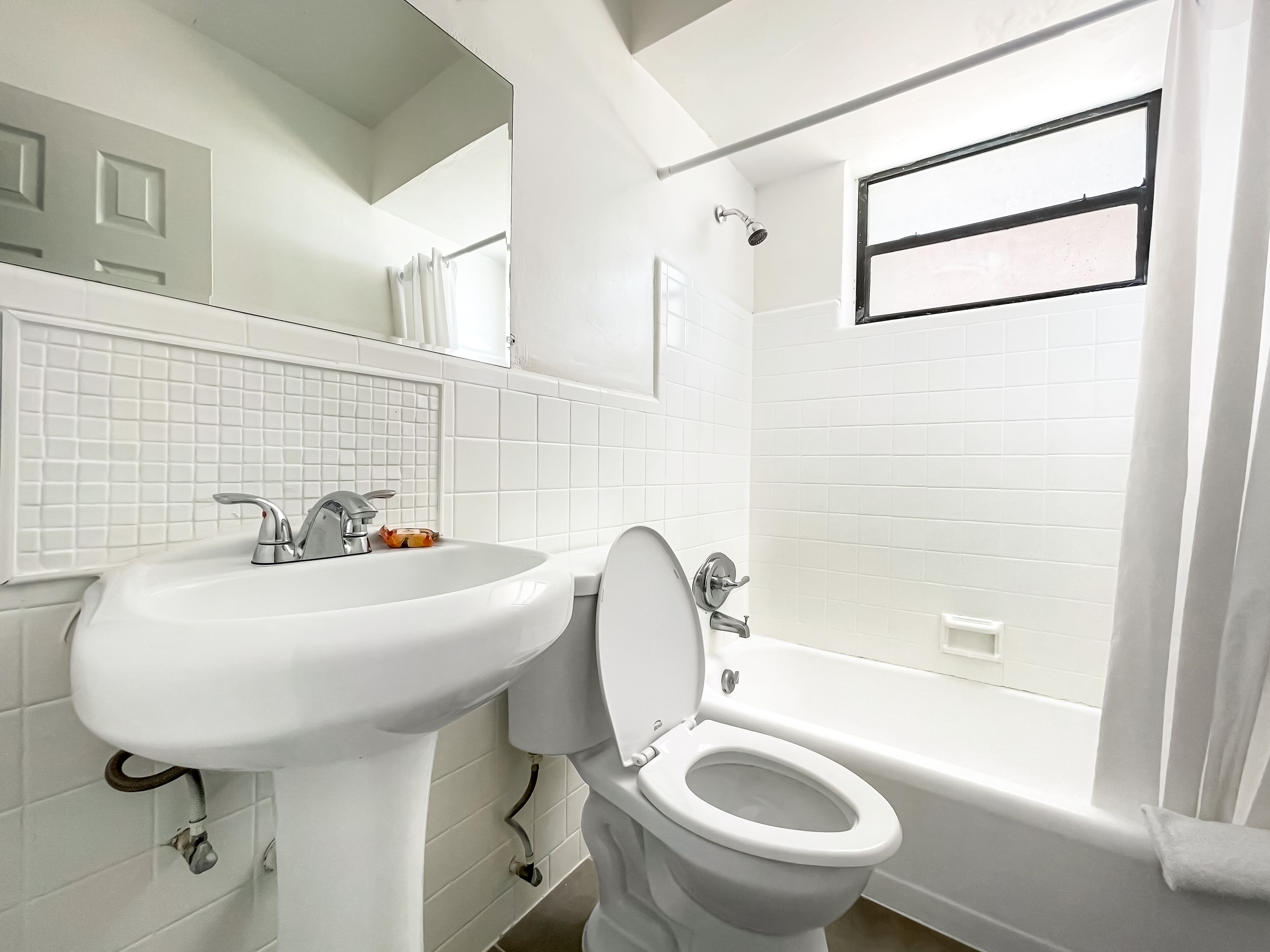 A bathroom with a white sink, toilet, and bathtub.
