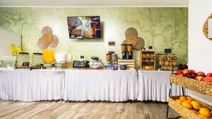 Una barra de desayuno con diversos alimentos y un televisor mostrando un mensaje.