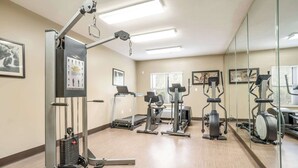 A gym with exercise equipment, a treadmill, and a mirrored wall. - Sleep Inn & Suites Jacksonville near Camp Lejeune (Jacksonville)