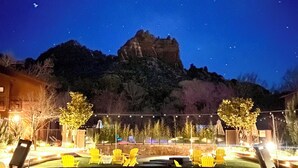 A patio area with outdoor seating and a view of a mountain at night. - Amara Resort and Spa (Sedona)