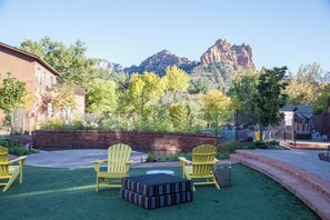 A patio with yellow Adirondack chairs, a small round table, and a brick wall. - Amara Resort and Spa (Sedona)