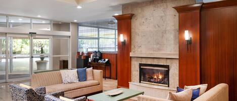 A lobby with a fireplace, seating area, and a reception desk.
