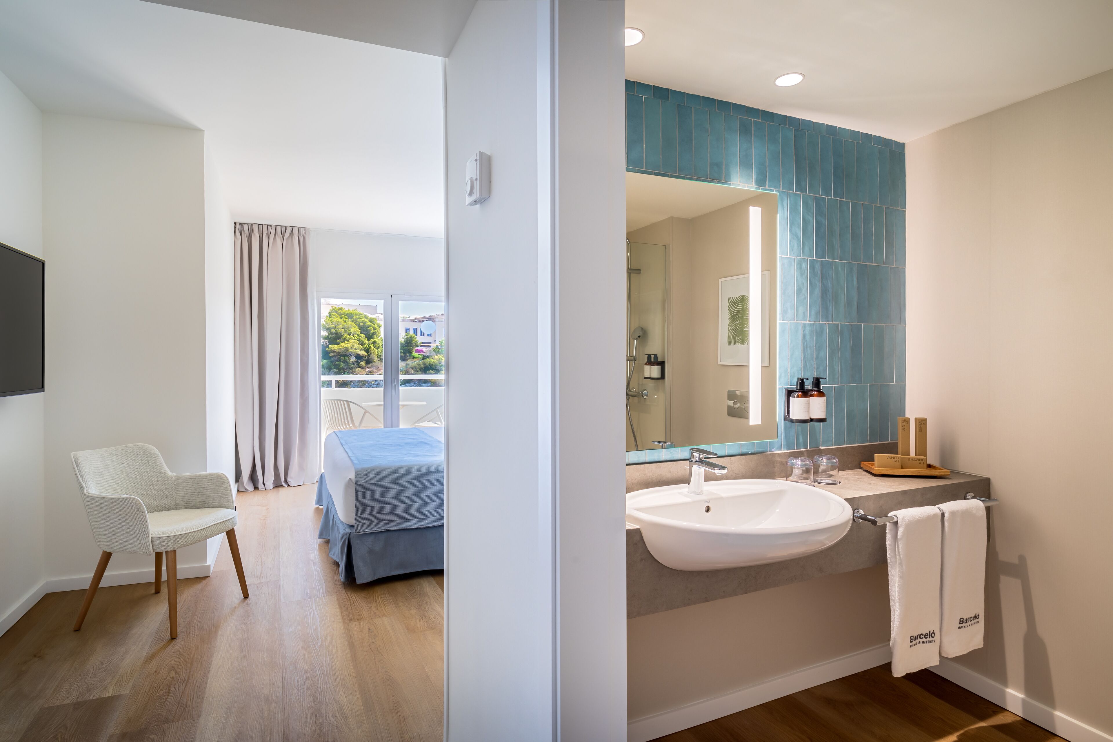A modern bathroom with a large mirror, a sink, and a towel rack.