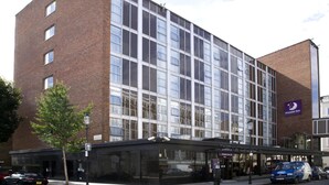 A modern building with a glass facade, a prominent Premier Inn sign, and a covered entrance area. - Premier Inn London Kensington (London)