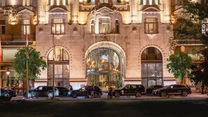 A grand building with ornate architecture, large arched windows, and a prominent entrance. - Four Seasons Gresham Palace (Budapest)