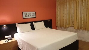 A hotel room with a bed, a bedside table with a phone, and a wall-mounted picture. - Riomar (Lagos)