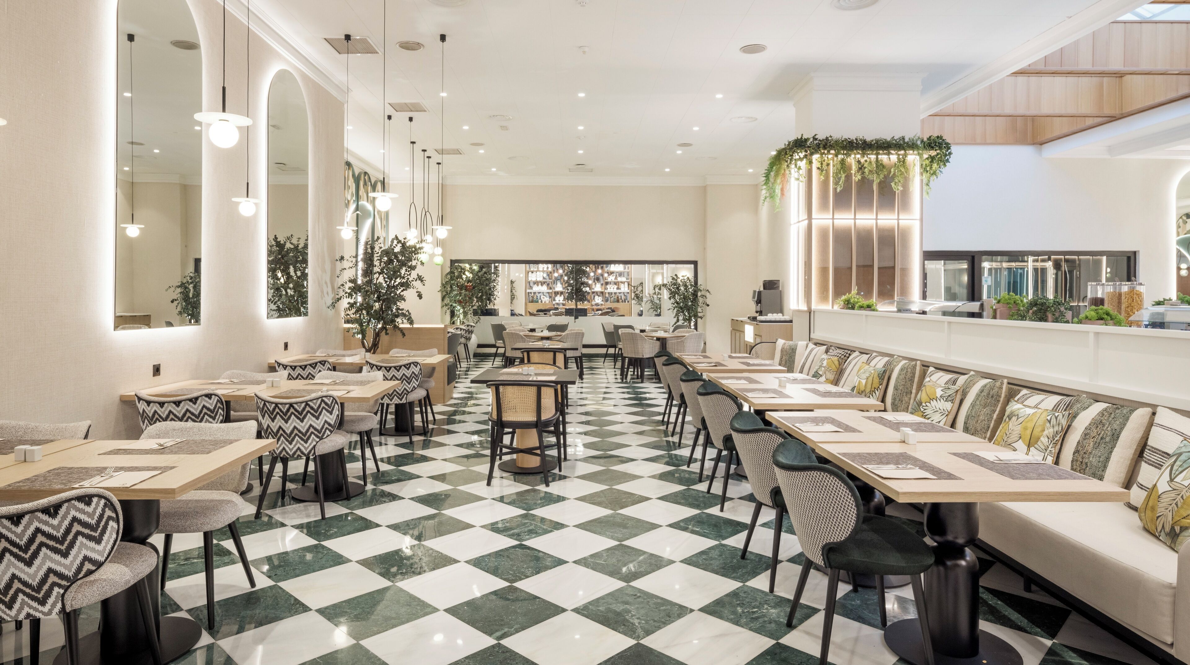 A restaurant with a checkered floor, multiple seating areas, and a view of the kitchen through large windows.