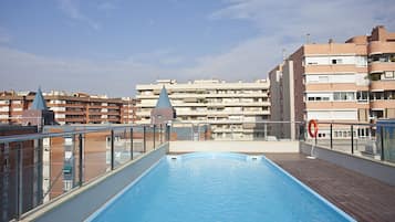 Een buitenzwembad, ligstoelen bij het zwembad