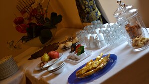 Un bufé de desayuno con diversas opciones de comida, entre ellas frutas, pasteles y salsas.