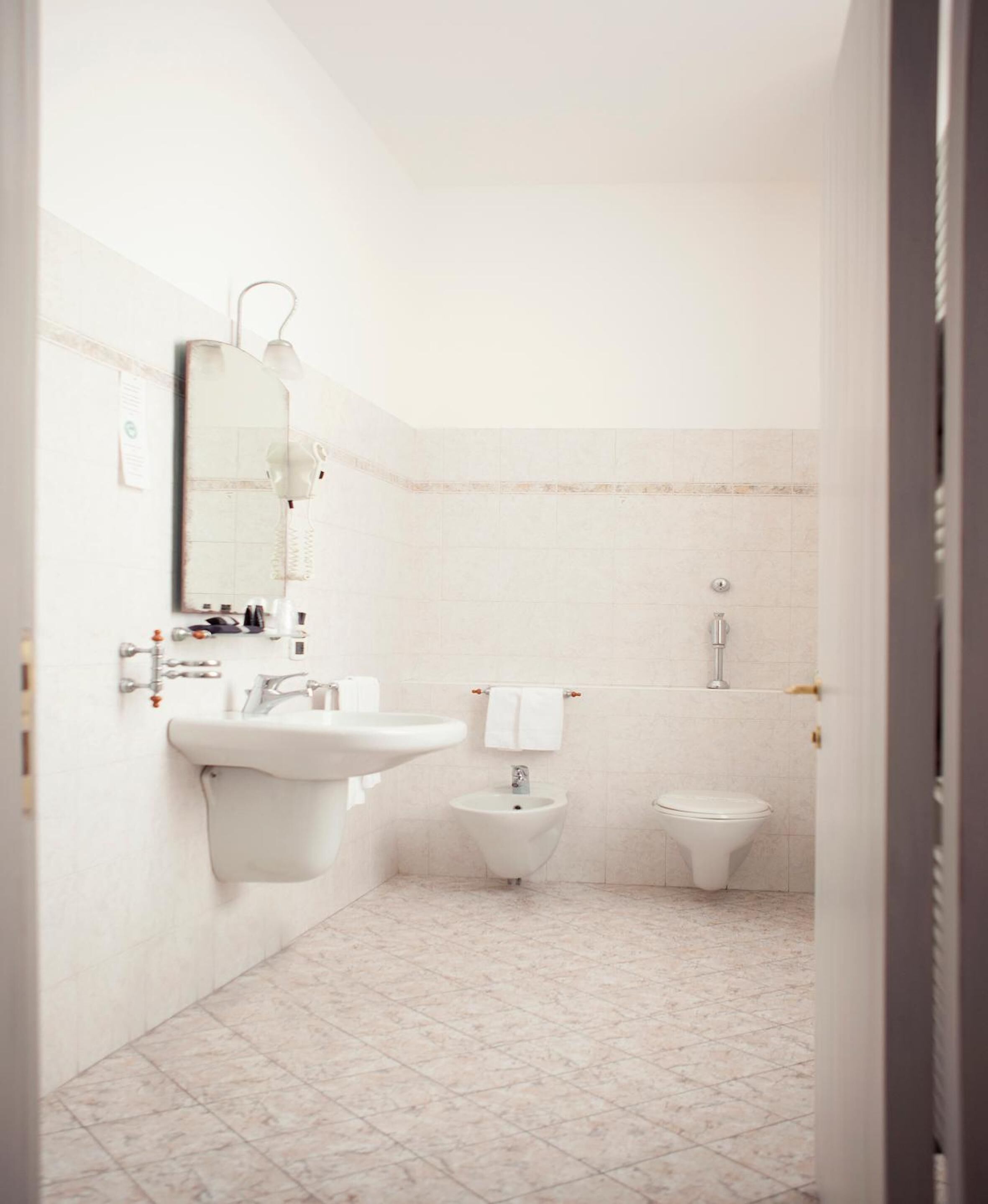 Ein kleines, sauberes Badezimmer mit Waschbecken, Bidet und Toilette.