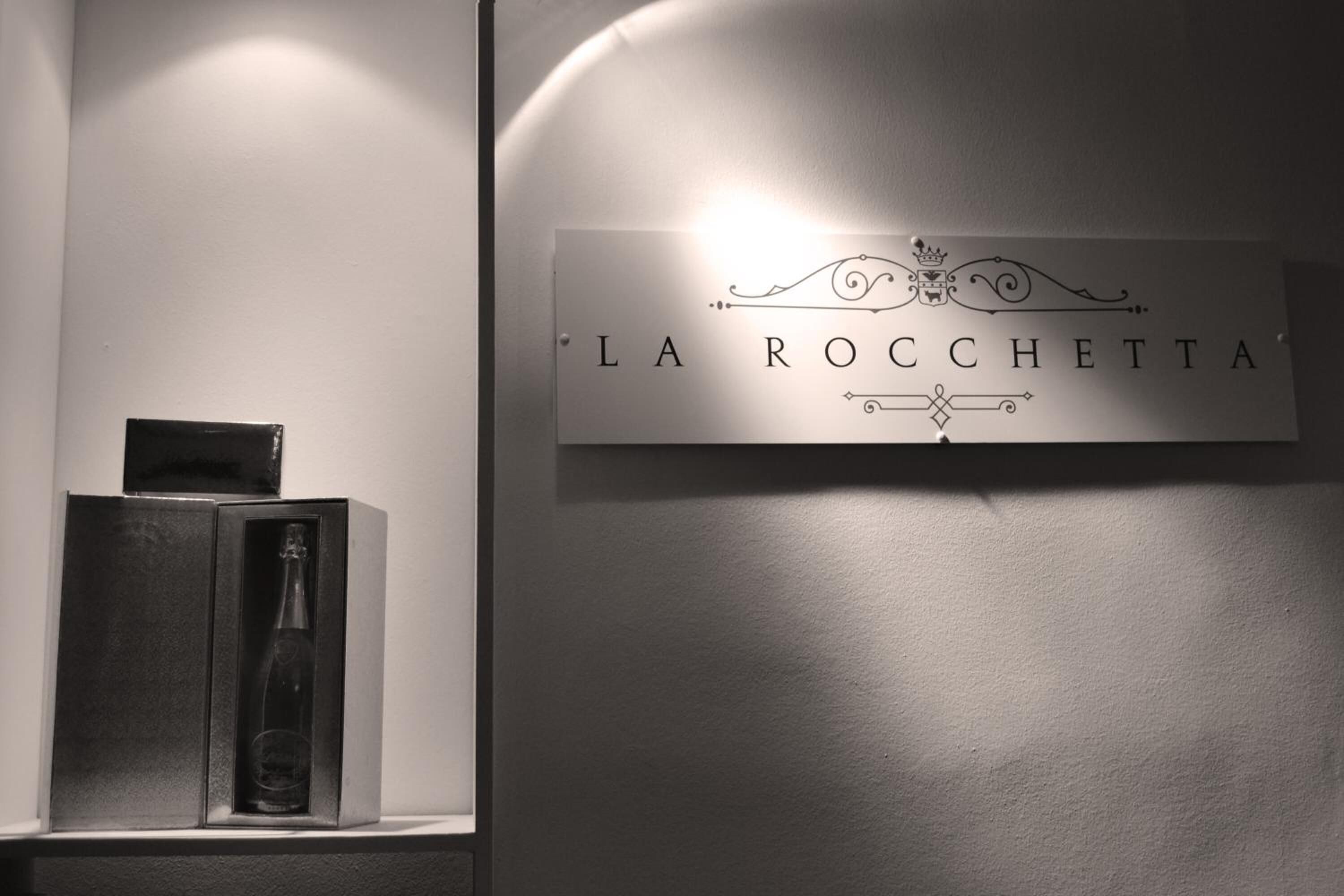 A wall-mounted sign with the text "LA ROCCHETTA" and decorative elements.