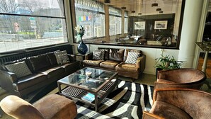 A modern living room with a sofa set, a glass coffee table, and a zebra-patterned rug.