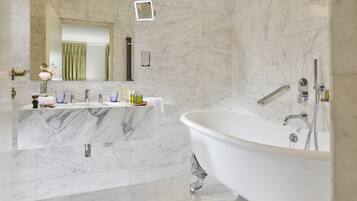 Ein modernes Badezimmer mit Marmorwaschtisch, freistehender Badewanne und großem Spiegel.