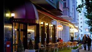 A hotel entrance with a marquee, outdoor seating, and a Christmas tree. - Artim Hotel (Berlin)