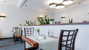 Un comedor con una mesa larga, sillas y una barra.
