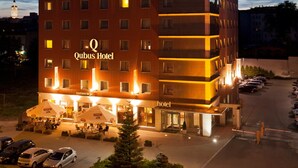 Un hotel de varios pisos con un letrero llamativo que dice "Qubus Hotel".