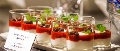 Un buffet de desserts avec des verrines à parfaits étiquetées « Yaourt dessert « Crunch » ».