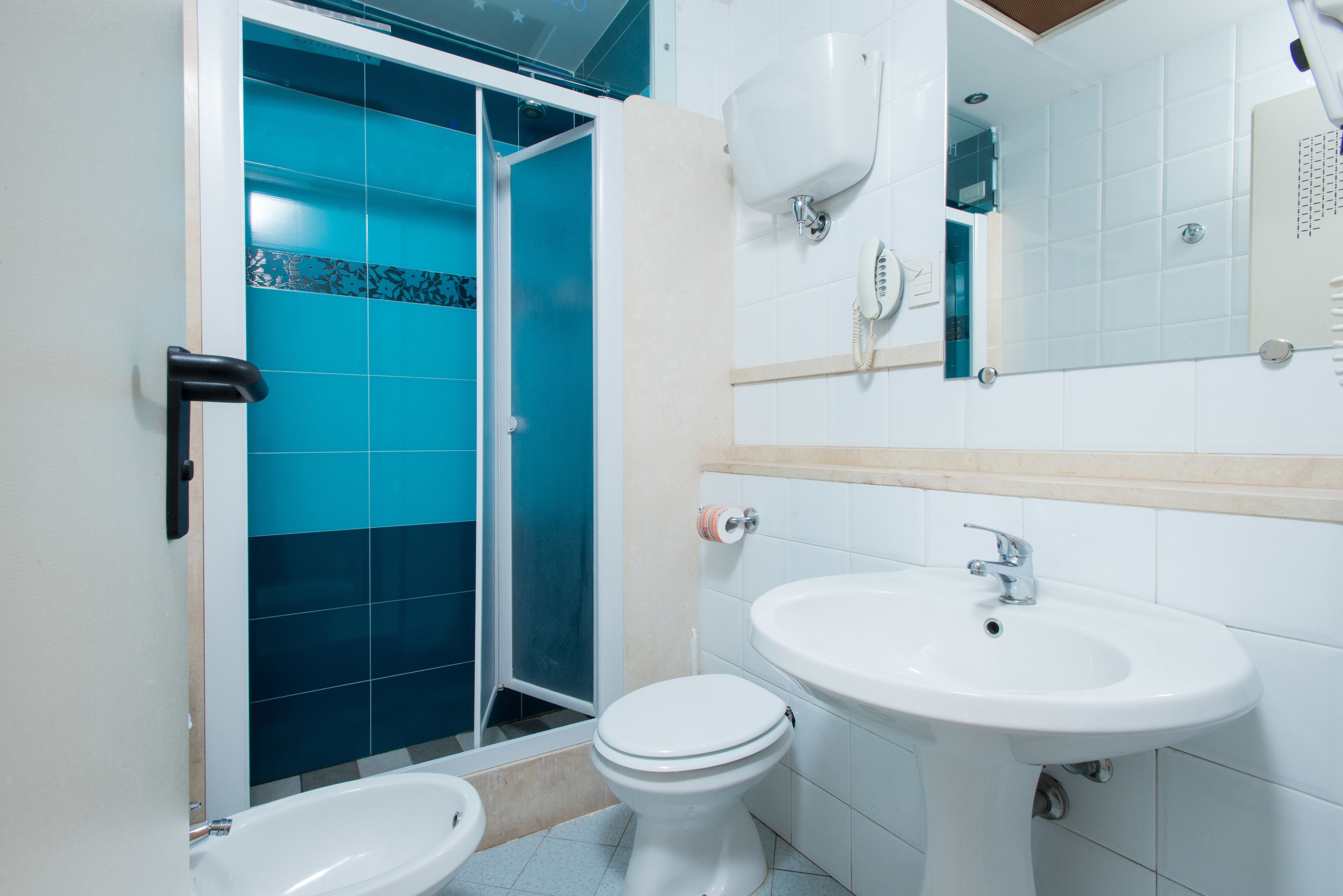Un baño con ducha, inodoro y lavamanos.