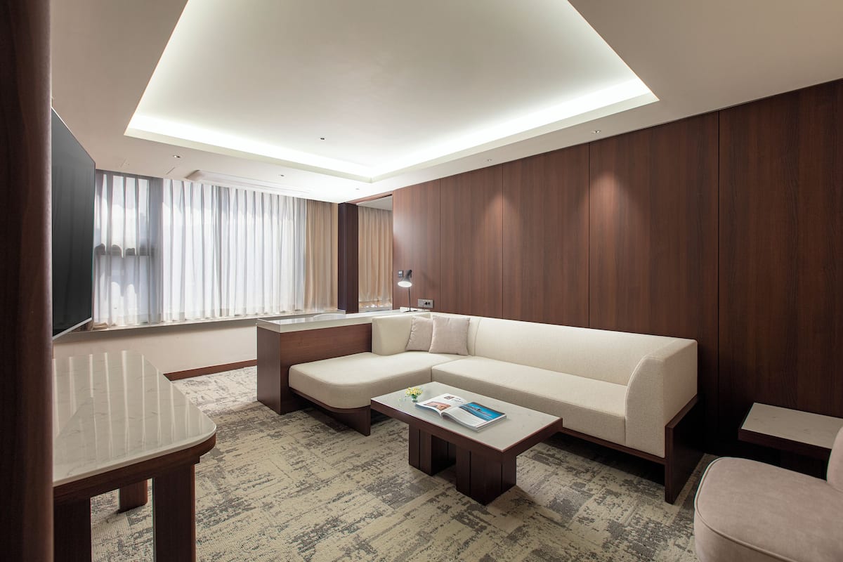 A modern living room with a sectional sofa, a coffee table, and a TV.