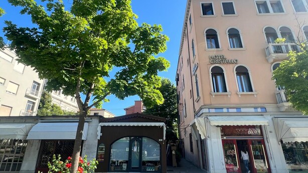 A building labeled "HOTEL CRISTALLO" with a covered entrance and a tree in front. - Hotel Cristallo (Venice)