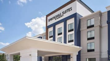 A hotel with a modern facade, a covered entrance, and a sign reading 'SPRINGHILL SUITES BY MARRIOTT'.