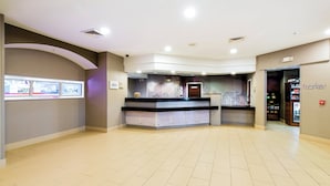 A spacious lobby with a reception desk, a large window display, and a 'market' sign on the wall.
